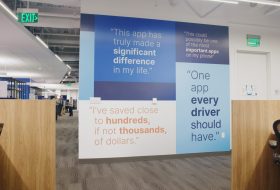 Open-office space with a large blue wall mural of quotes about apps and life.